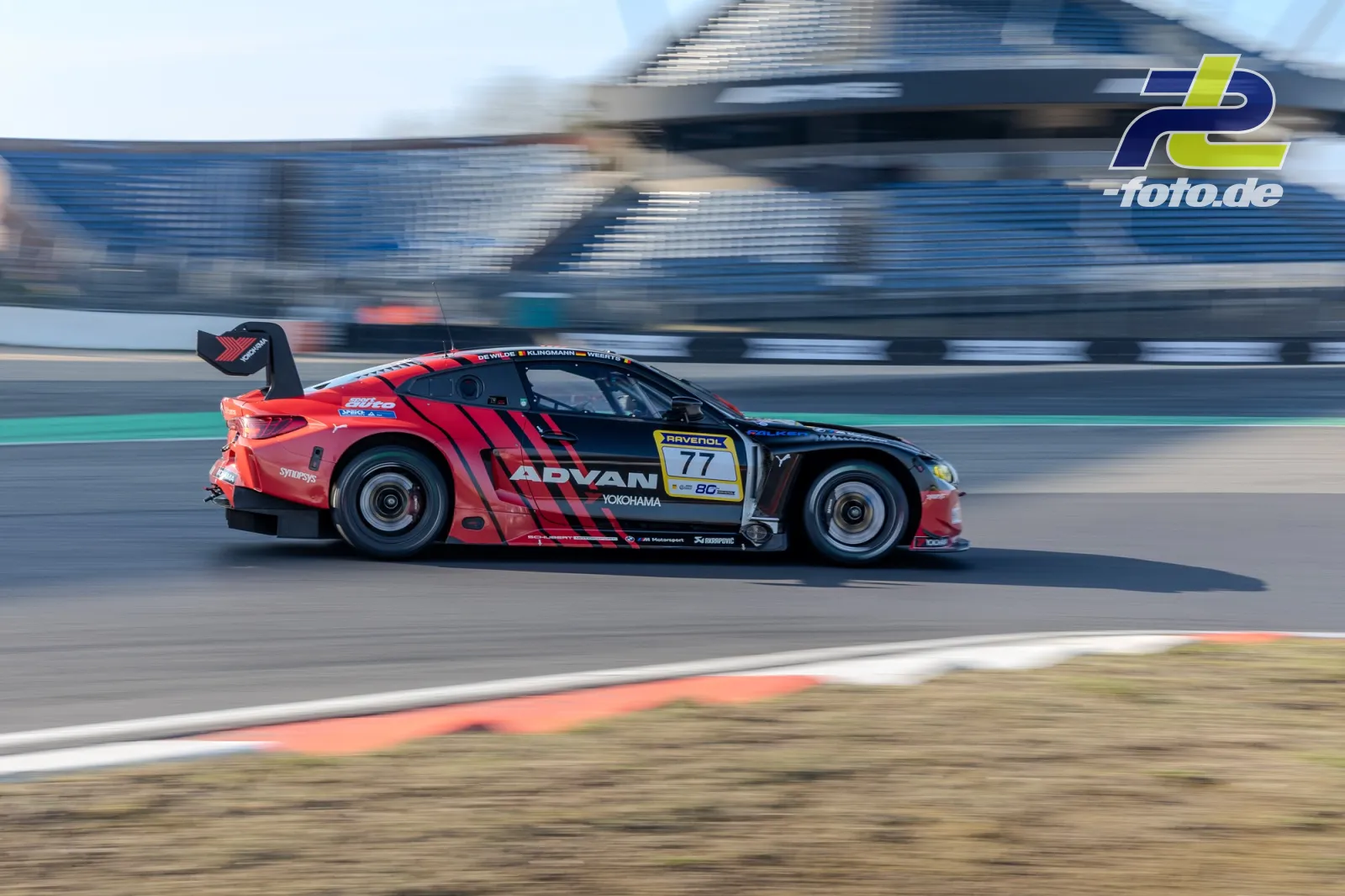 BMW M4 GT3 EVO #77 mit rot-schwarzer Lackierung im Zeittraining auf dem Nürburgring, aufgenommen als Mitzieher.