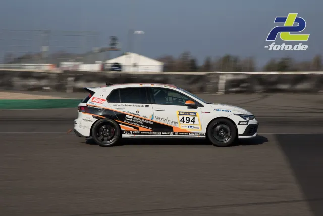 Weißer Rennwagen mit Startnummer 494 in der Seitenansicht auf der Rennstrecke des Nürburgrings während des NLS-Laufs.