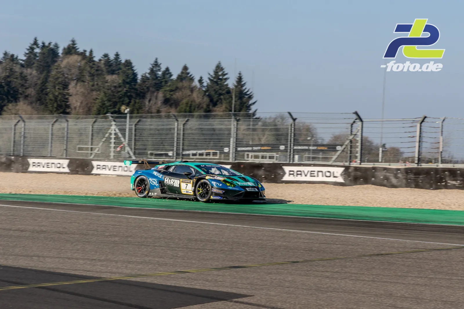 Lamborghini Huracán GT3 EVO #7 in türkis-blauer Lackierung passiert ein Kiesbett beim Zeittraining auf dem Nürburgring.