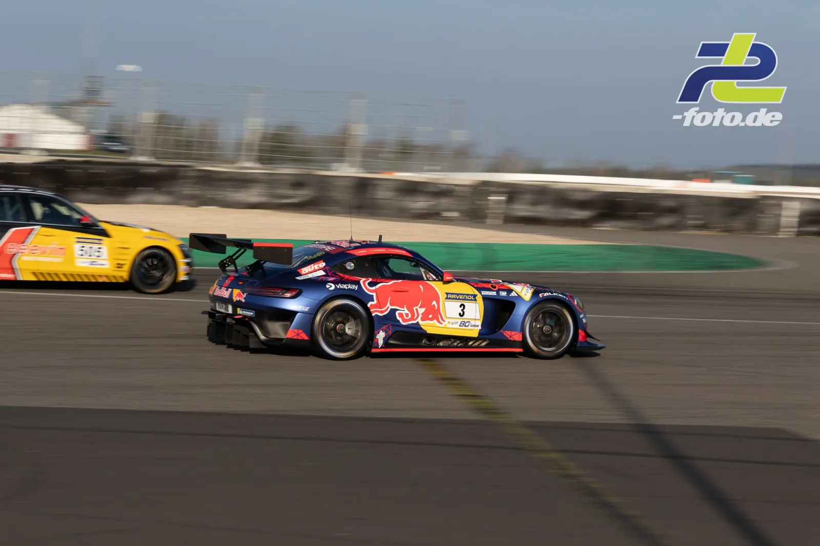 Zwei Rennwagen auf der Nordschleife beim Zeittraining, im Vordergrund ein Audi mit Red Bull-Lackierung, dahinter ein gelber Konkurrent.