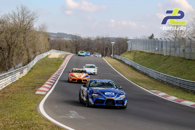 Mehrere Rennwagen auf der Nordschleife während des NLS-Rennens, angeführt von einem blauen Toyota Supra.