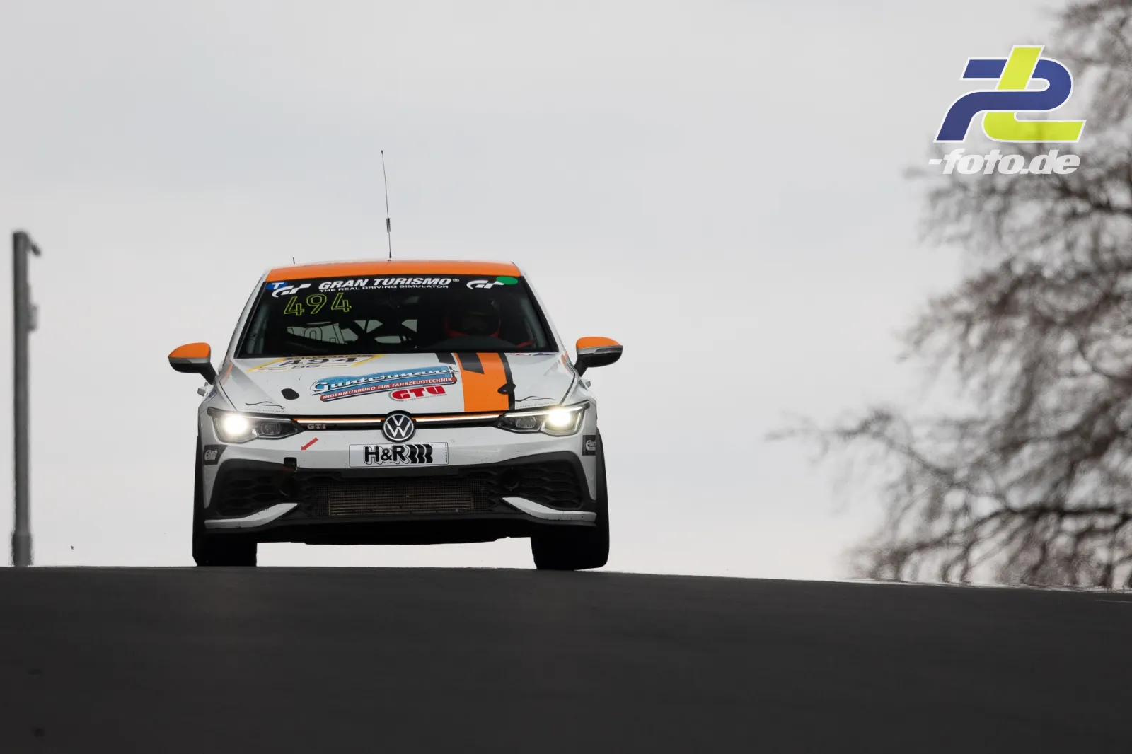 VW Polo GTI im Sprung über die Kuppe am Nürburgring, Frontansicht bei bedecktem Himmel während des ADAC Barbarossapreis.