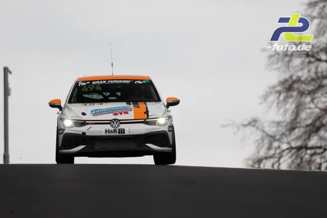 VW Polo GTI im Sprung über die Kuppe am Nürburgring, Frontansicht bei bedecktem Himmel während des ADAC Barbarossapreis.