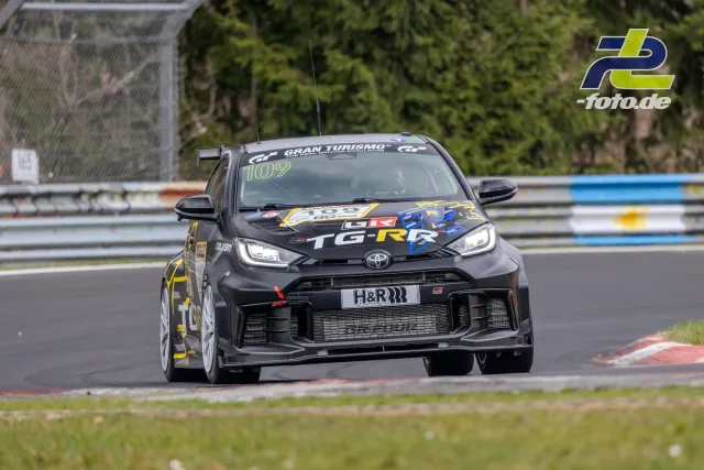 Toyota GR Yaris mit Startnummer 109 im Rennen auf dem Nürburgring, schwarze Lackierung mit bunten Sponsorenaufklebern.