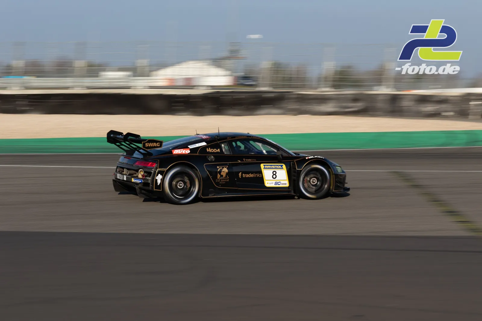 Audi R8 LMS GT3 mit Startnummer 8 in schwarz-gelber Lackierung im Mitzieher auf der Nordschleife während des Zeittrainings