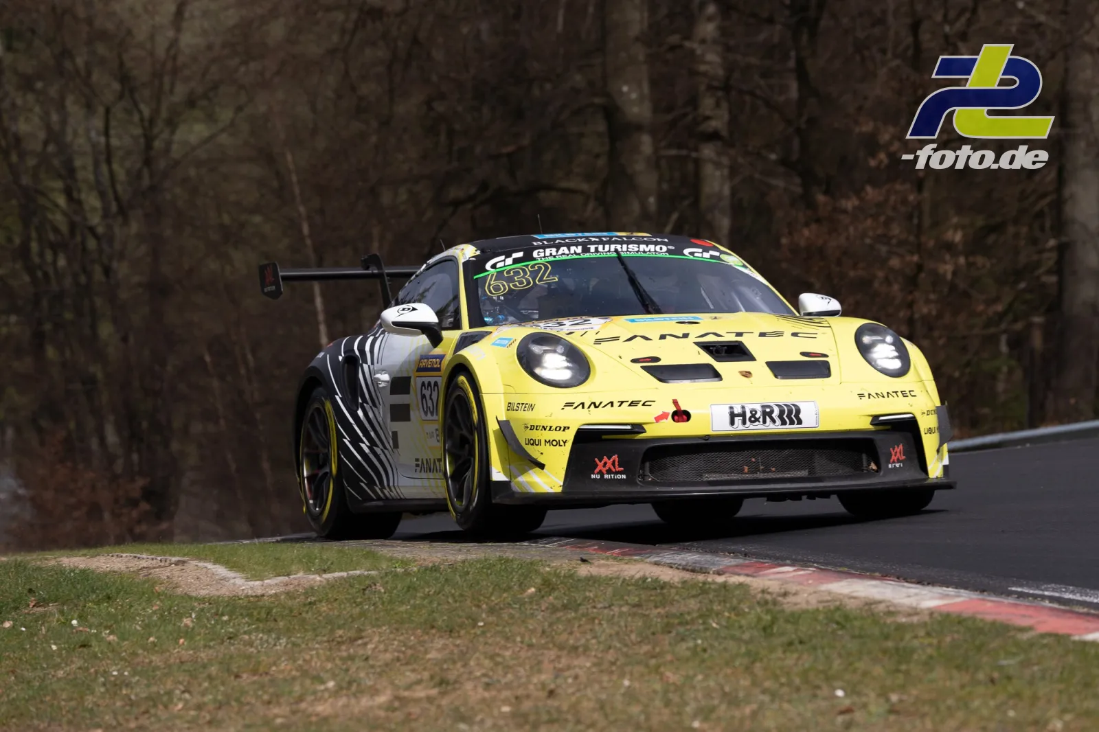 Gelber Porsche 911 GT3 R mit Startnummer 632 in Kurve auf der Nordschleife beim NLS-Rennen.