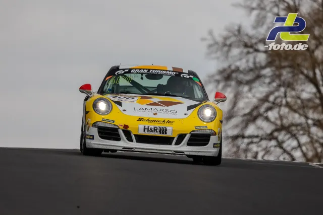 Porsche 911 mit Startnummer 400 in Kuppe am Nürburgring bei bedecktem Himmel während des NLS-Rennens.