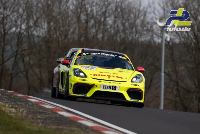Porsche Cayman GT4 Clubsport in leuchtend gelber RHEOSOL-Lackierung während des Rennens auf der Nordschleife im trüben Licht