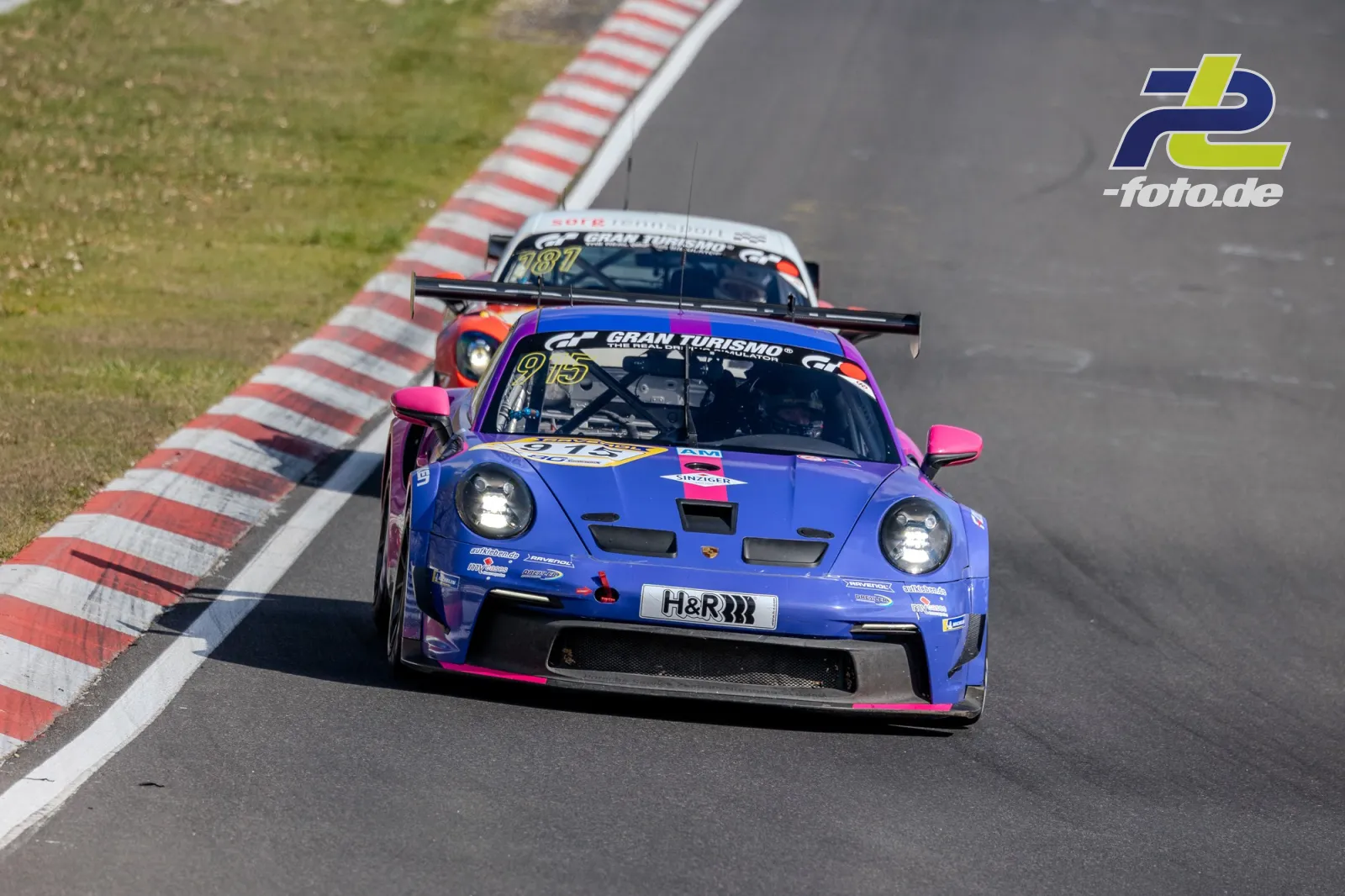 Zwei Porsche 992 GT3 Cup in Kurve auf der Nordschleife während des NLS-Rennens, vorne ein blau-pinker Porsche mit Startnummer 913.
