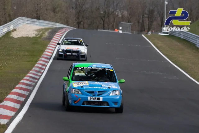 Zwei Rennfahrzeuge auf der Nordschleife bei Tageslicht während des NLS-Rennens am Nürburgring.