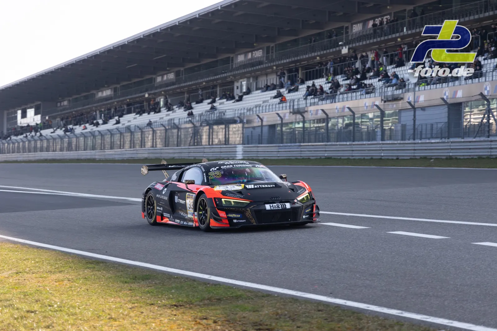 Audi R8 LMS GT3 in schwarz-rot auf der Döttinger Höhe vor der Haupttribüne während des Zeittrainings am Nürburgring.