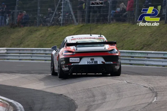 Porsche 911 in rot-weißer Lackierung von hinten in einer Kurve auf dem Nürburgring beim ADAC Barbarossapreis.