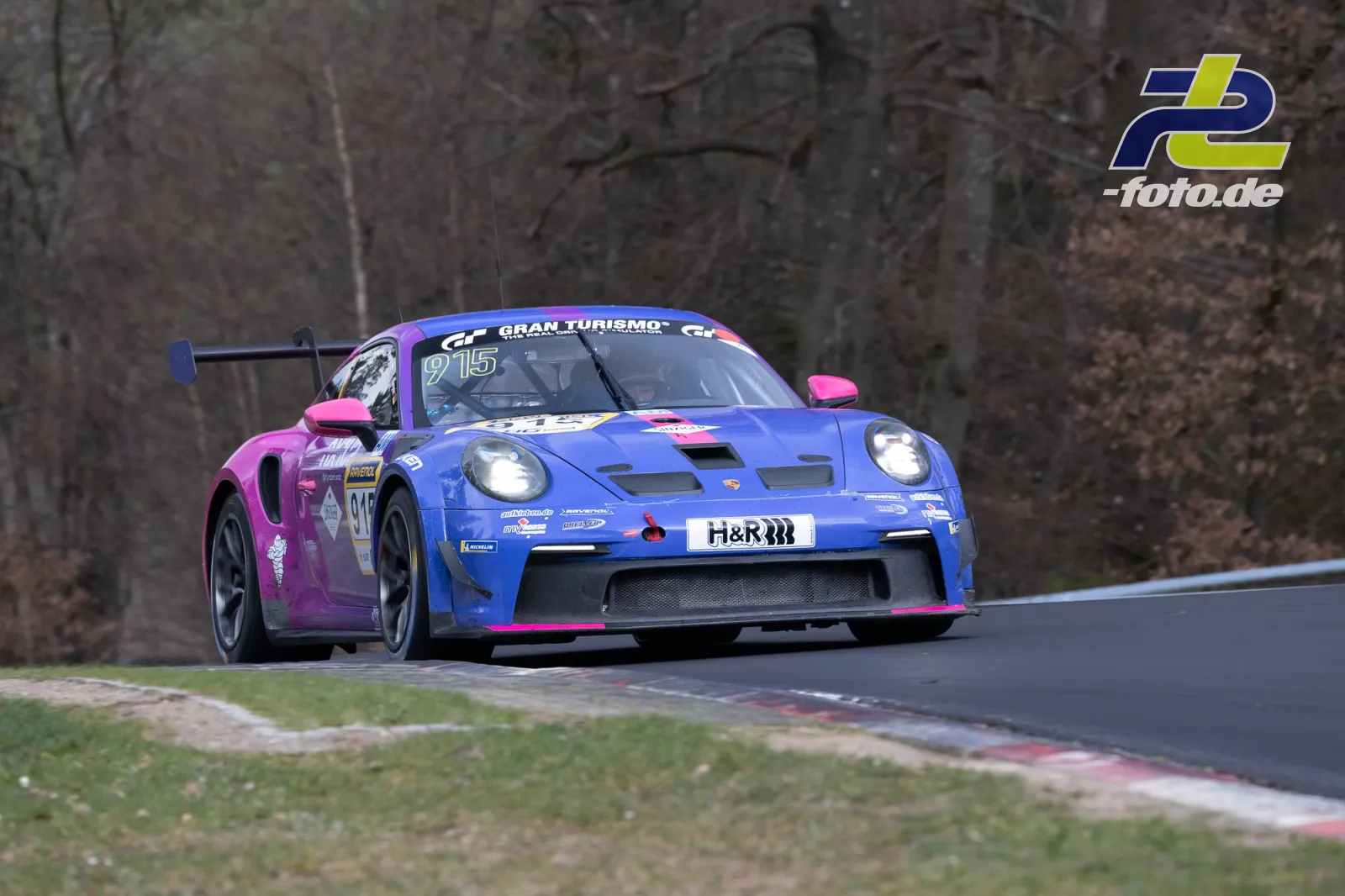 Porsche 911 GT3 Cup in blau-pink auf der Nordschleife beim NLS-Rennen mit H&R-Sponsoring und Gran Turismo-Aufkleber