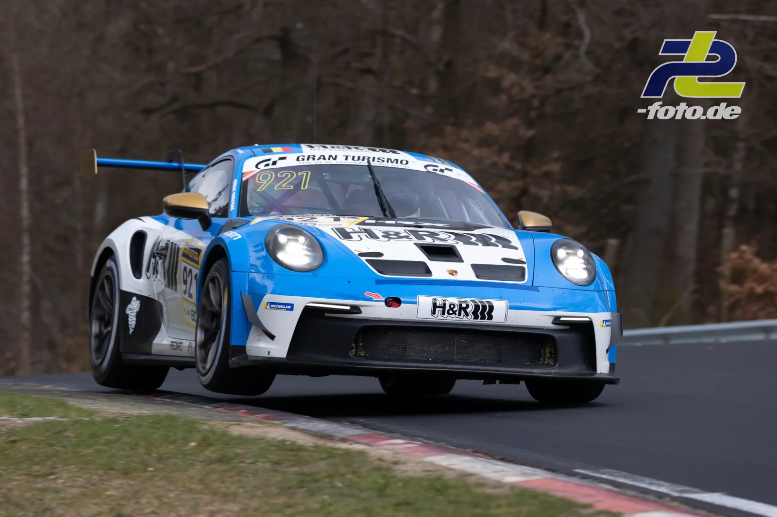 Porsche 911 GT3 R mit Startnummer 921 in blau-weißer Lackierung während des NLS-Rennens auf der Nordschleife des Nürburgrings.