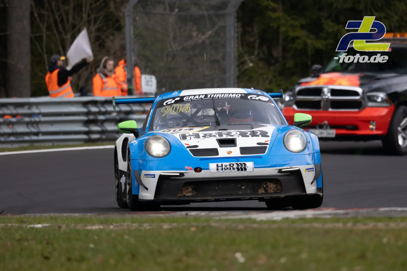 Porsche 911 GT3 Cup mit Startnummer 904 in blau-weißer Lackierung während des Rennens auf dem Nürburgring, gefolgt von weiteren Fahrzeugen.