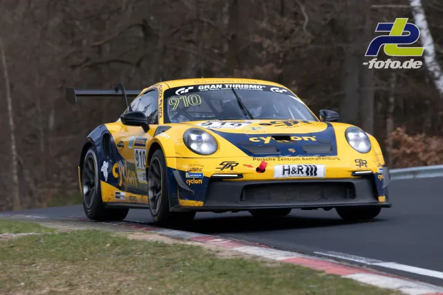 Gelber Porsche 911 GT3 Cup #910 in einer Kurve auf der Nürburgring-Nordschleife beim NLS-Rennen.
