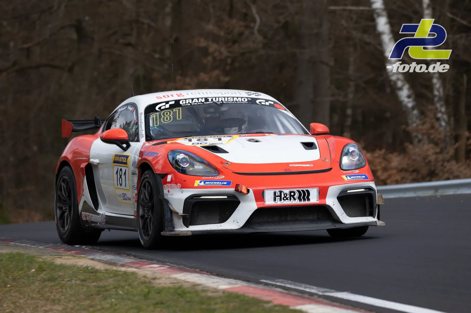 Porsche Cayman GT4 Clubsport in orange-weißer Lackierung während des Rennens auf der Nordschleife am Nürburgring.