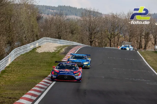 Drei GT3-Fahrzeuge in einer Reihe durch eine Kurve auf dem Nürburgring, Bergkulisse im Hintergrund.