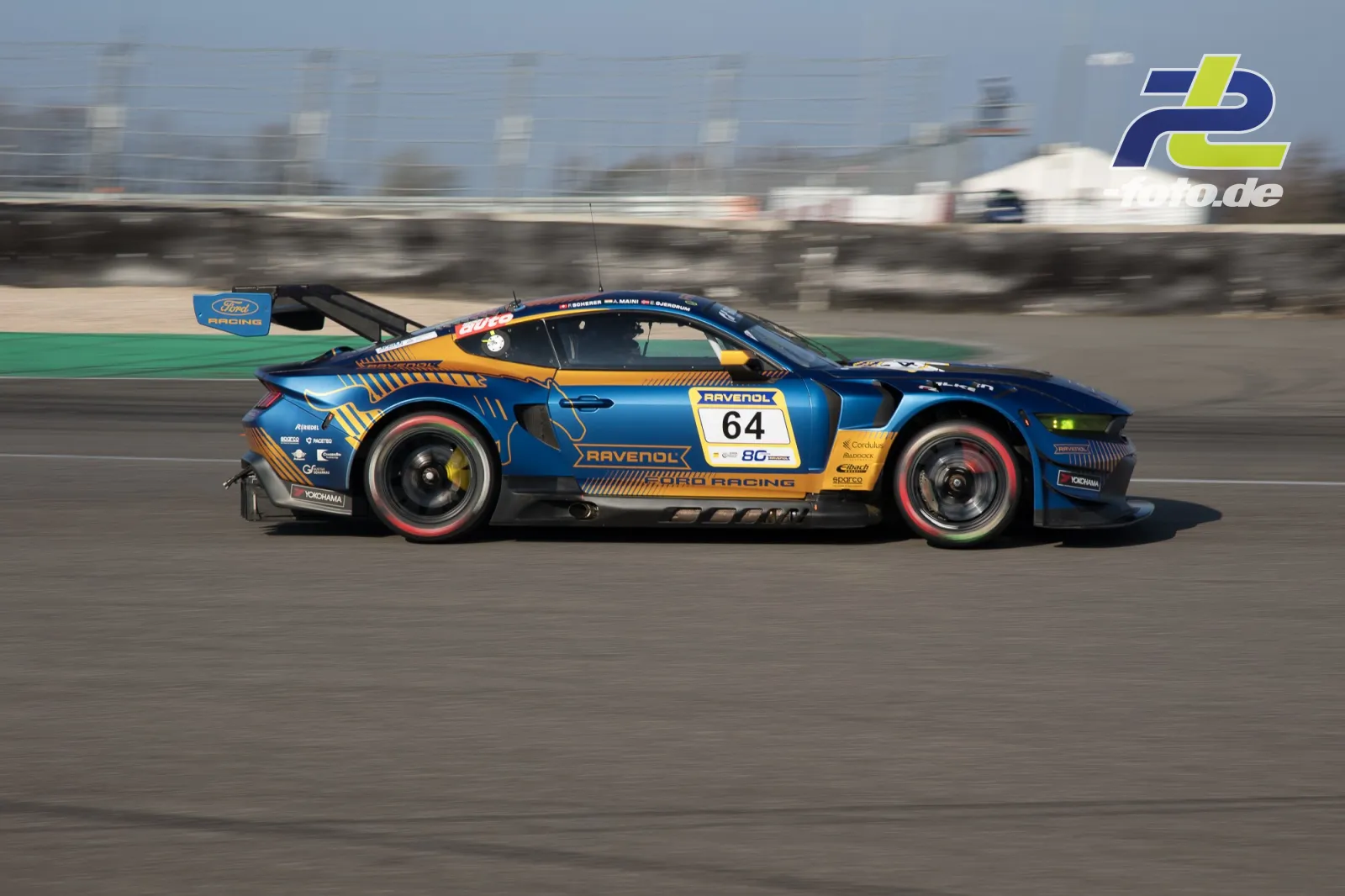 Ford Mustang GT3 Nr. 64 von RAVENOL ZCORD RACING in blau-orange Lackierung auf dem Nürburgring, Seitenansicht in voller Fahrt.