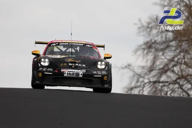 Porsche 911 GT3 Cup mit schwarzer Lackierung und gelben Spiegeln fliegt über die Kuppe am Nürburgring