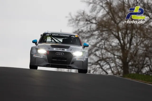 Audi Rennwagen mit Startnummer 321 springt über Kuppe auf der Nürburgring-Nordschleife beim NLS-Rennen.