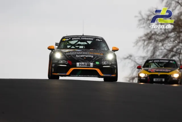 Zwei Fahrzeuge auf der Bergauf-Passage der Nürburgring-Nordschleife bei bewölktem Wetter während des Rennens.