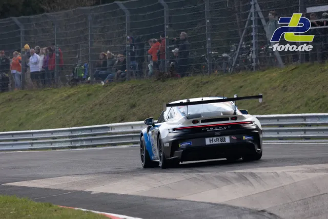 Porsche 911 GT3 Cup in weiß-blauer Lackierung auf der Nordschleife beim 58. ADAC Barbarossapreis, Zuschauer am Streckenrand