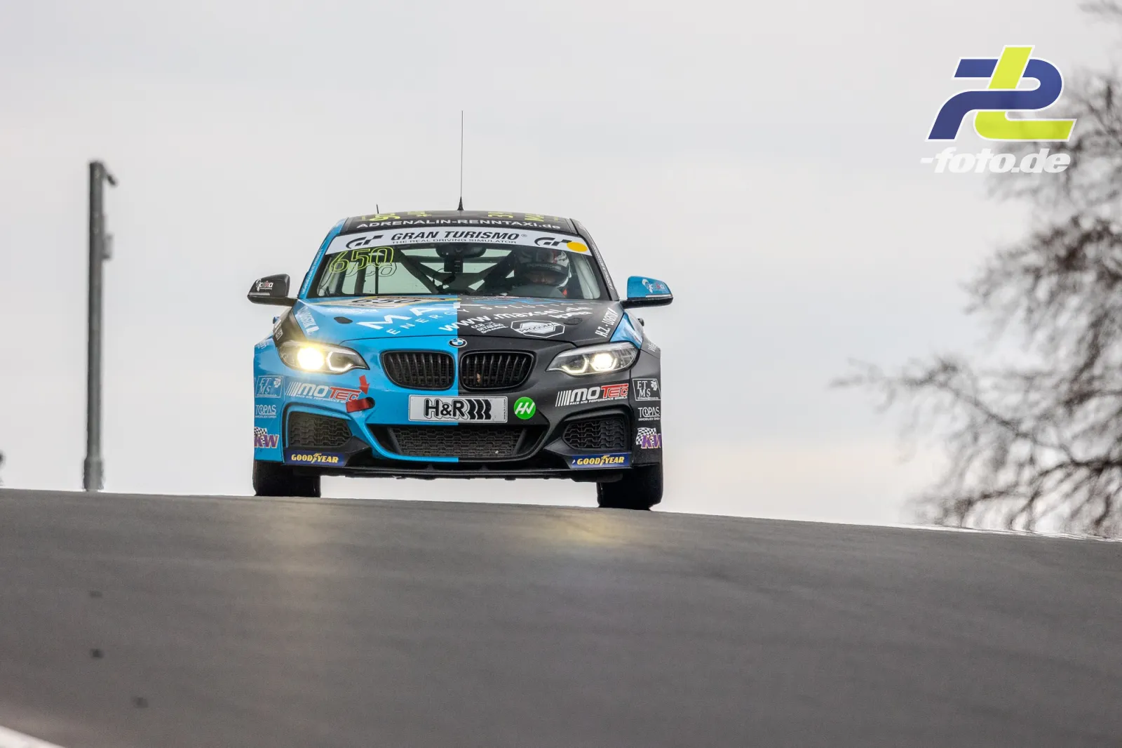 BMW M240i mit blau-schwarzer Lackierung auf einer Kuppe der Nürburgring-Nordschleife beim NLS-Rennen