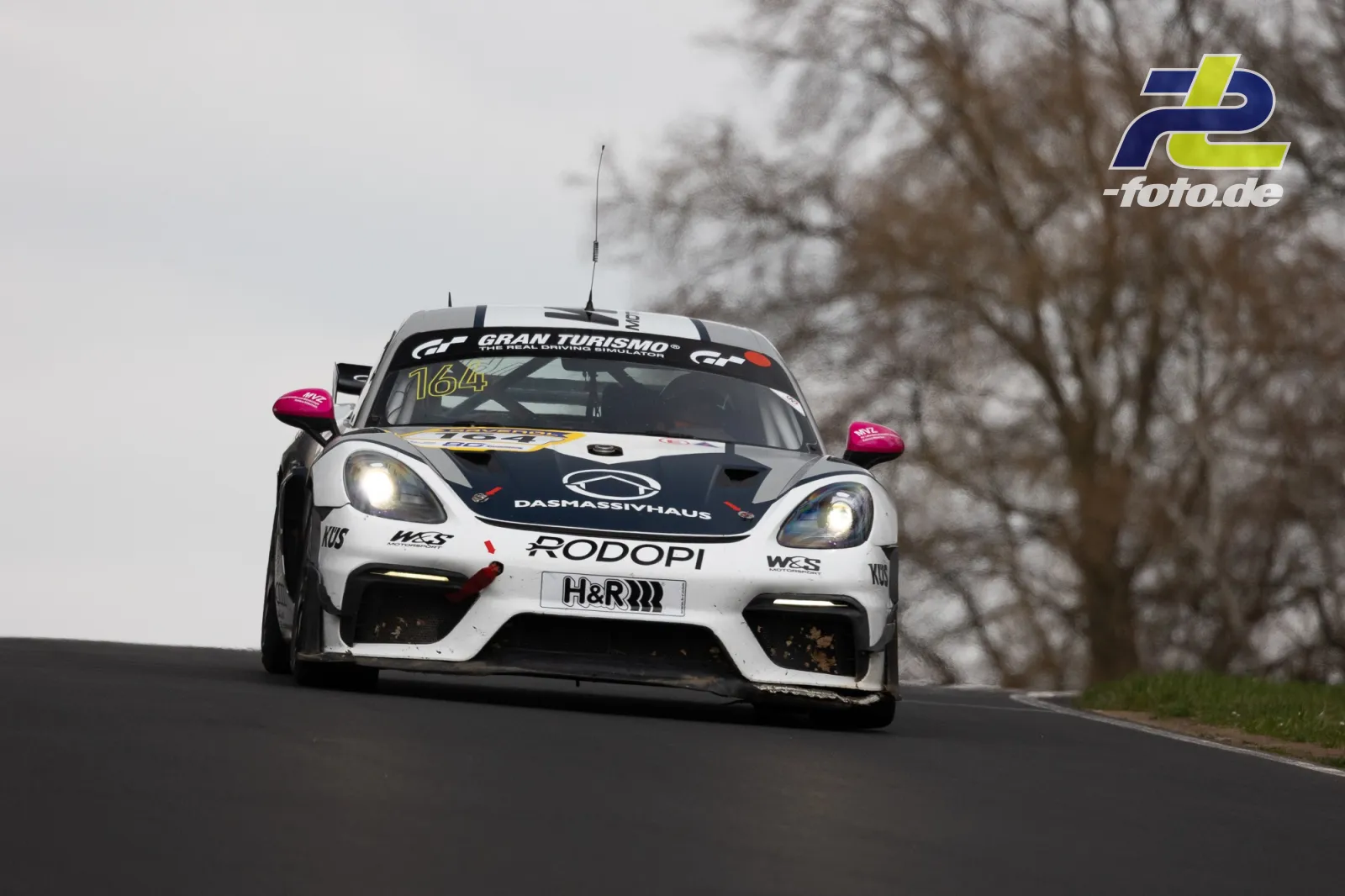 Porsche Cayman GT4 Clubsport Nr. 164 auf der Nordschleife bei bewölktem Wetter während des NLS-Rennens am Nürburgring.