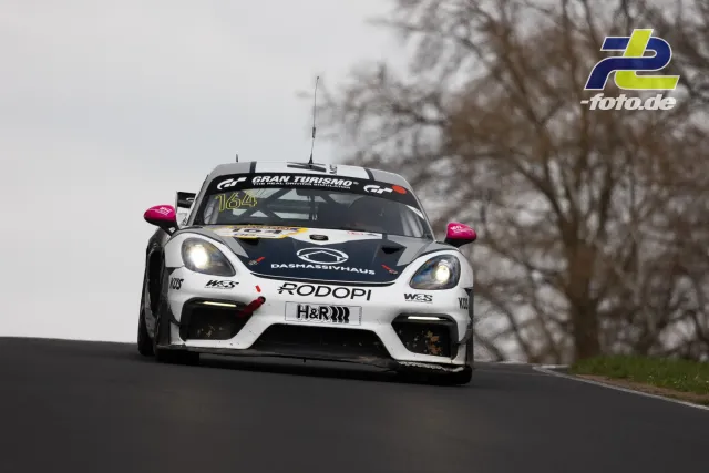 Porsche Cayman GT4 Clubsport Nr. 164 auf der Nordschleife bei bewölktem Wetter während des NLS-Rennens am Nürburgring.