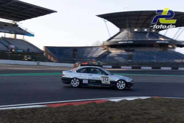 BMW E46 mit Startnummer 254 auf der Nordschleife vor der Haupttribüne beim Zeittraining.
