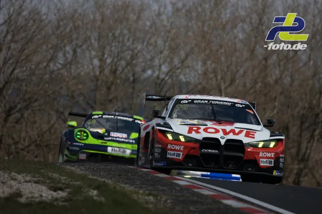 BMW M4 GT3 im ROWE-Design führt vor einem Porsche auf der Nordschleife durch eine Kuppe, NLS Barbarossapreis.
