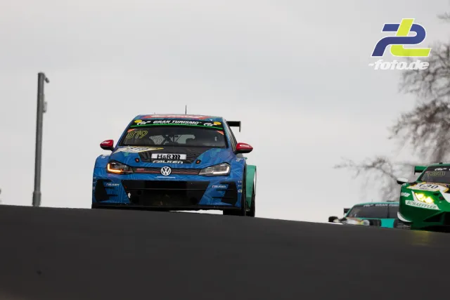 VW Golf TCR mit Startnummer 819 und grün-gelber Porsche auf Kuppe der Nordschleife bei trübem Himmel