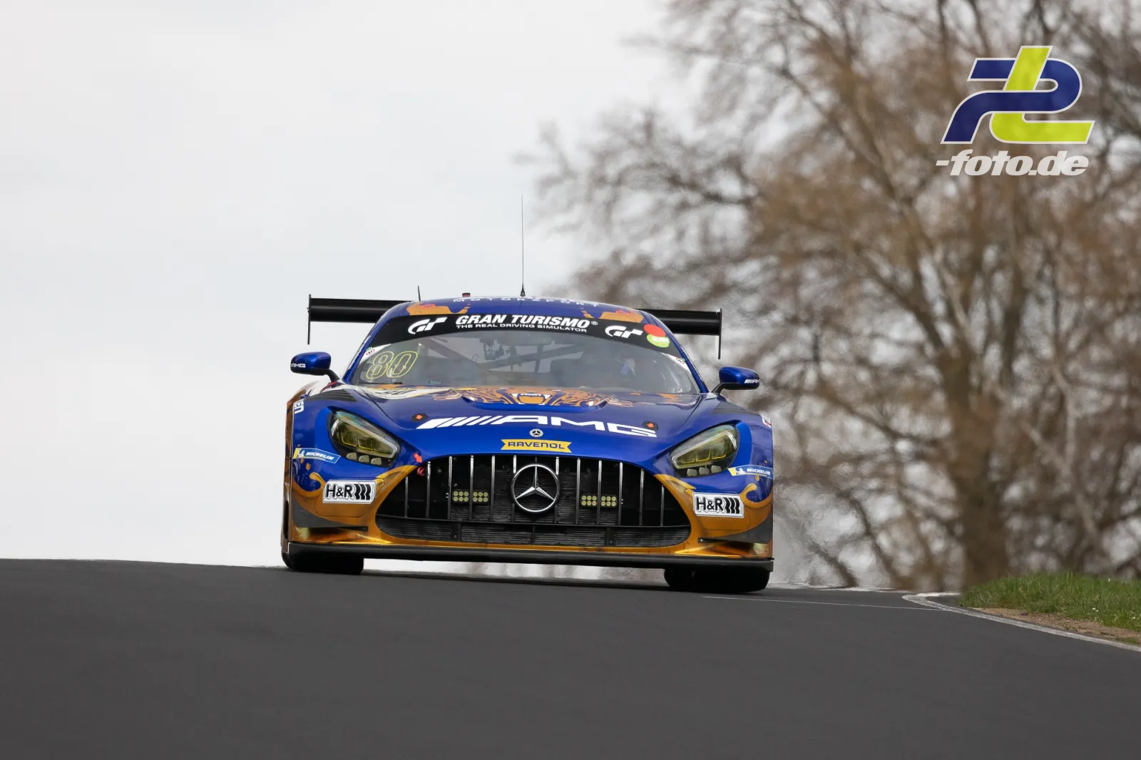 Mercedes-AMG GT3 #80 in blau-goldener Lackierung über eine Kuppe auf der Nürburgring Nordschleife beim NLS Rennen.