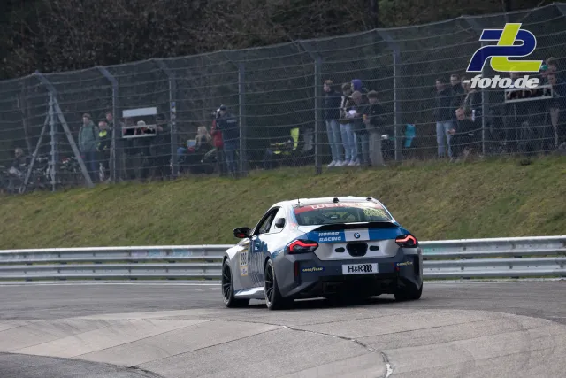 BMW M2 G87 Cup von Hofor Racing in Kurve auf dem Nürburgring, Zuschauer am Zaun, Heckansicht