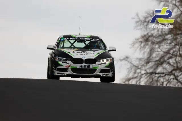 BMW Rennwagen mit Motorsportlackierung springt über Kuppe auf dem Nürburgring