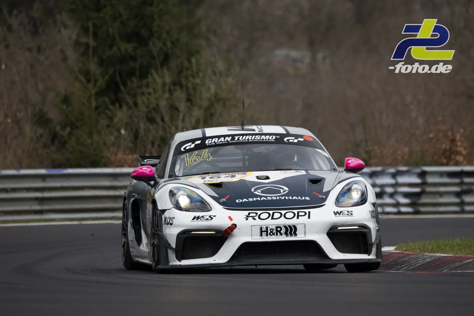 Porsche Cayman GT4 CS MR #164 in weiß-schwarz mit pinken Spiegeln auf der Nordschleife beim NLS-Rennen