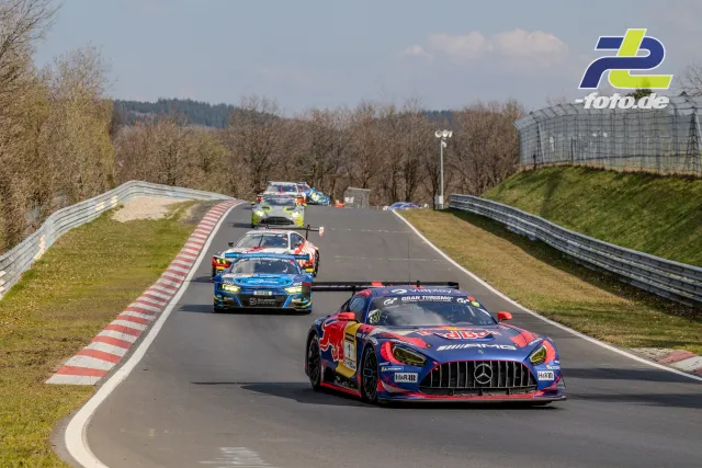 Rennfahrzeuge in Reihe auf der Nordschleife, angeführt von einem Mercedes-AMG GT3 in Red-Bull-Lackierung auf einer Geraden am Nürburgring.