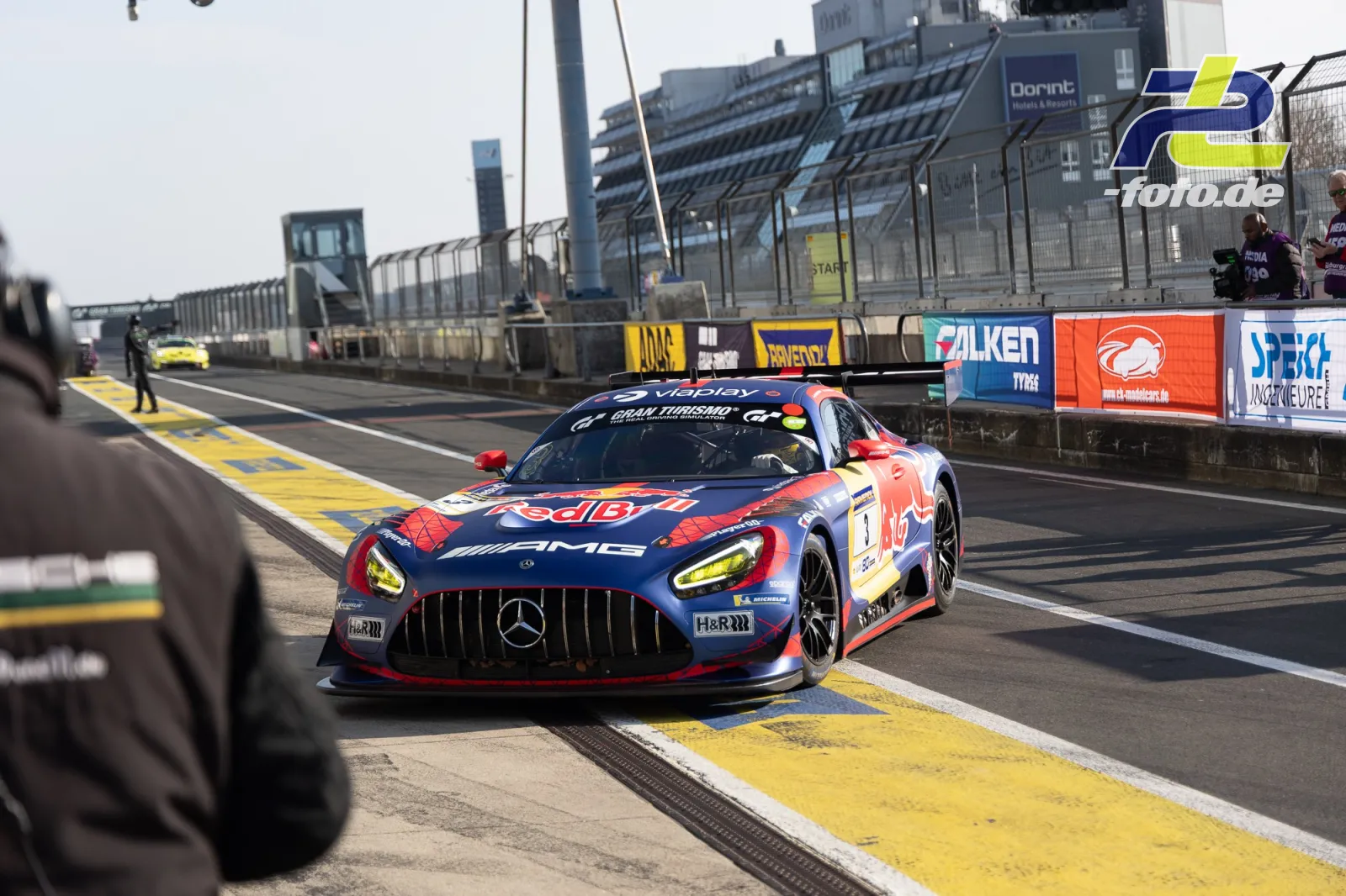 Mercedes-AMG GT3 #1 in Red Bull-Lackierung fährt aus der Boxengasse des Nürburgrings, weitere Fahrzeuge im Hintergrund.