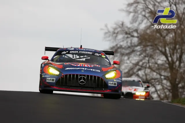 Mercedes-AMG GT3 mit Red Bull-Lackierung überquert die Kuppe bei trübem Wetter auf der Nordschleife, gefolgt von einem weiteren GT3-Fahrzeug.