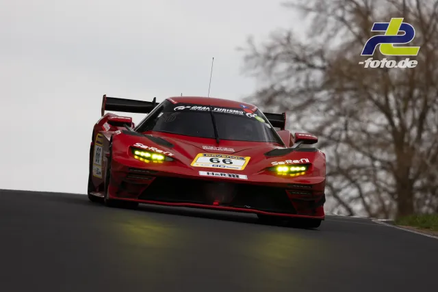 Roter KTM X-BOW GTX mit Startnummer 66 in voller Fahrt auf dem Nürburgring bei trübem Wetter.