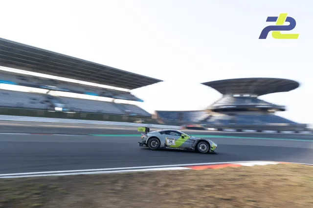 Aston Martin Vantage GT3 mit Startnummer 34 in silber-neongelber Lackierung auf der Nordschleife, Mitzieher am Nürburgring.