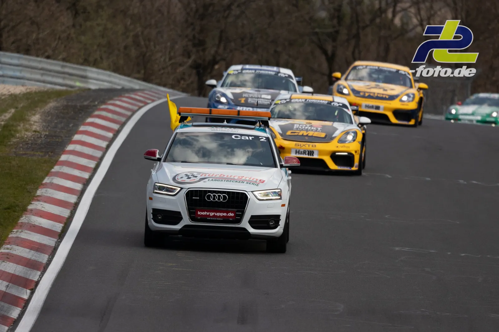 Weißes Audi Safety Car führt Feld auf der Nordschleife an, gefolgt von gelben Porsche Cayman und weiteren Rennwagen.