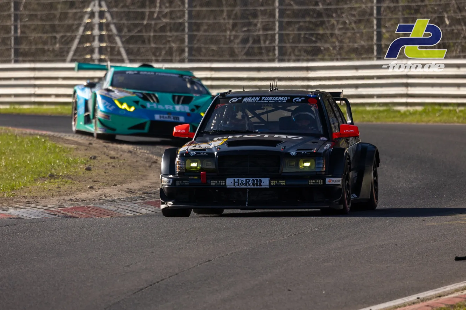 Zwei Rennwagen in der Kurve beim Zeittraining auf dem Nürburgring, schwarzer Klassiker vor türkisem GT-Rennwagen.