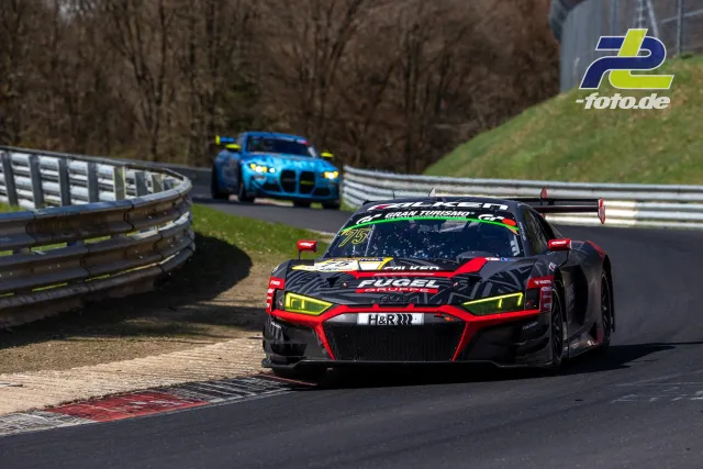 Zwei Rennwagen in einer Kurve auf dem Nürburgring, vorn ein Audi R8 LMS in schwarz-rot-gelb, dahinter ein blauer BMW M4 GT3.