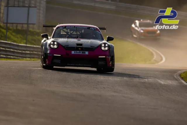Porsche im Gran Turismo Design fährt auf der Nürburgring-Nordschleife, verfolgt von einem weiteren Fahrzeug.