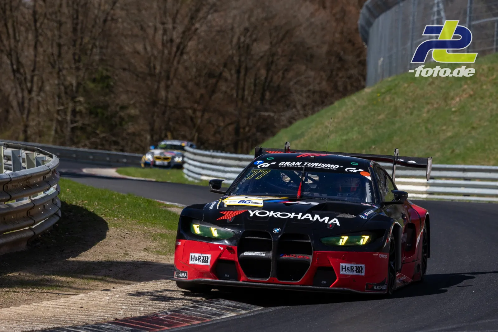 BMW mit Yokohama-Sponsoring auf der Nordschleife, weiteres Fahrzeug im Hintergrund während NLS-Rennen.