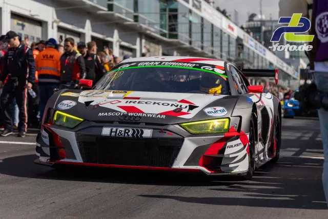 Audi R8 LMS GT3 Nummer 19 fährt in der Boxengasse am Nürburgring, Mechaniker und Zuschauer im Hintergrund.