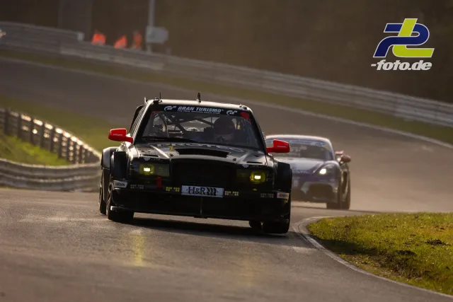 HWA EVO.R mit Gran Turismo-Banderole in Kurve auf der Nordschleife, verfolgt von weiterem Fahrzeug