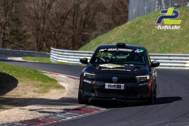 Schwarzer Kleinwagen mit Startnummer 380 in Kurve auf der Nordschleife, Gran Turismo-Branding, H&R-Kennzeichen